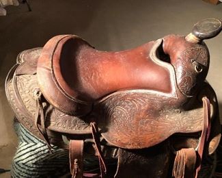 #36)  $350 -  1940's Carved Leather Saddle by Monroe Saddle Company with accessories.  #40 Oklahoma Roper.  Comes with 2 blankets, a bridal headstall, a couple of cinches, ropes, reigns and other assorted leather accessories.  