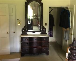 Marble Top Victorian Serpentine Front Dresser with Pierced Carved Yoke holding a Plate Glass Framed Mirror Attributed to one of the New Orleans Furniture Maker
