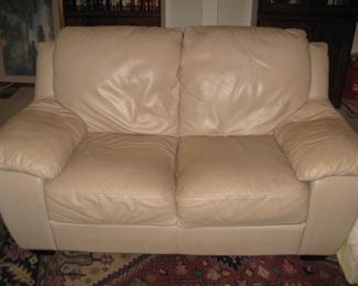 Leather loveseat. 2 matching ottomans available 