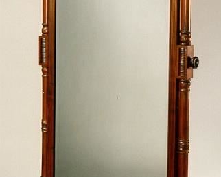 A WILLIAM IV MAHOGANY CHEVAL MIRROR  CIRCA 1835
The rectangular mirrored plate with rounded corners and cushioned surround, swiveling between two scrolled uprights each fitted with a brass articulated candlearm and joined by turned stretchers, on scrolling feet with casters
5 ft. 3 in. high; 39 in. wide; 23 in. deep
