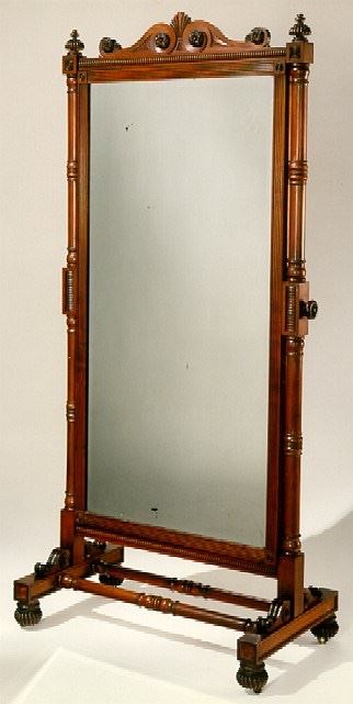 A WILLIAM IV MAHOGANY CHEVAL MIRROR  CIRCA 1835
The rectangular mirrored plate with rounded corners and cushioned surround, swiveling between two scrolled uprights each fitted with a brass articulated candlearm and joined by turned stretchers, on scrolling feet with casters
5 ft. 3 in. high; 39 in. wide; 23 in. deep