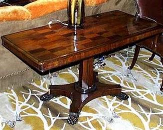 A WILLIAM IV ROSEWOOD AND PARQUETRY LIBRARY TABLE, 19TH CENTURY
The rounded rectangular top inset with rectangles of parquetry above a faceted stem and quatripartite plinth, with paw feet and recessed casters
28 in. high; 4 ft. 5 in. wide; 24 1/4 in. deep              Appraised Value: $3500.00