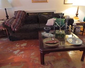 Three cushion couch with large soft pillows.    Glass and Mahogany frame glass coffee table  42" square   On the table, folding metal candle stand, 5 branches.  Large, studio made pottery plate also studio made pottery box w/ lid, more  