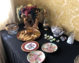 Table with figural plateau with grapes $30   Gold-tone flatware, $1 each,  violet teapot $15, 