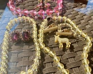 Lot 1343.  $65.00. Seven Piece Vintage Lot of Jewelry - 3 vintage glass bead necklaces, 2 yellow and one pink with matching pink earrings.  Purple stunning clip on vintage earrings, tiny pearl sweater clips, one plastic donkey with itty bitty stones		