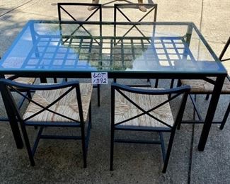 Lot 1392.  $325.00 Glass and metal dining table and 6 metal frame chairs with rush seats ( 2 of the seats need screws to attach seats to frames). 31"x57.5"x30" tall