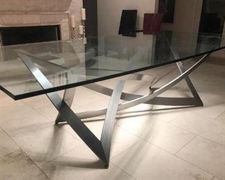 Lot #943 - $3,200 - Offsite Item.  Custom Designed Sculptured Brushed Steel Dining Table with 3/4" Thick Glass Top with Bowed Curve on Long Edges (110" L x 46" W x  30" H), orig. $7,500