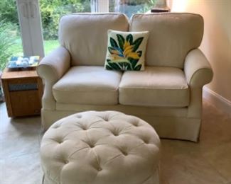 Light yellow loveseat and round ottoman
