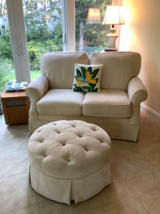 Light yellow loveseat and round ottoman