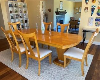 Absolutely fabulous modern dining table with 6 chairs. Chairs have been reupholstered in a faux leather. Table and chair are in mint condition, a beautiful maple color. The furniture company is high-end, and this set is around 30 years of age and has been discontinued. Fairmont Furniture co. Very shiny finish. There are two leave in the table, each is 14 in. With leaves in table is 92 in. in length. Priced at $950.00  