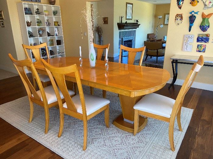 Absolutely fabulous modern dining table with 6 chairs. Chairs have been reupholstered in a faux leather. Table and chair are in mint condition, a beautiful maple color. The furniture company is high-end, and this set is around 30 years of age and has been discontinued. Fairmont Furniture co. Very shiny finish. There are two leave in the table, each is 14 in. With leaves in table is 92 in. in length. Priced at $950.00  