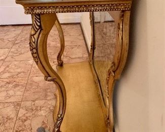Side view of gilt marble top console table 