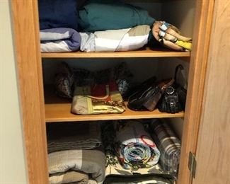 Closet full of blankets, sheets and other linens.