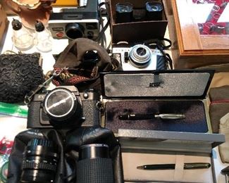 Smalls table, including cameras and lenses, nice pens, and more.