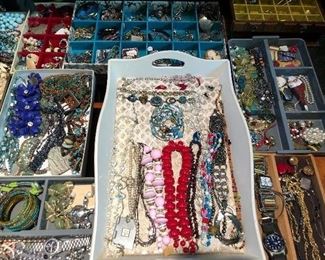 More trays packed with costume jewelry.