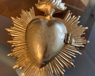 A beautiful Ex-Voto. This is an inscribed piece meant for one to hang in their home and put a special intention inside the heart. It has the Immaculate Mary insignia on the front and Sacred Heart flame. Hinged to open. Gold metal. A truly beautiful piece. $35