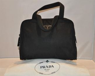 BLACK NYLON AUTHENTIC DOUBLE HANDLE PRADA LOCKING COSMETIC BAG WITH ONE INTERIOR POCKET, IN EXCELLENT CONDITION (WITH DUST COVER), 12"W X 8"H X 4"D. OUR PRICE $225.00
