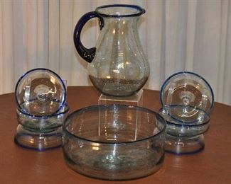 8 PIECE HAND BLOWN SET MADE IN MEXICO,  LARGE 9.5" ROUND SALAD BOWL, SIX 4.75" SIDE SALAD BOWLS AND A 8.5" PITCHER, CLEAR WITH BLUE TRIM. OUR PRICE $125.00