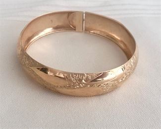 #31. -- Vintage 14k yellow gold lightweight bangle bracelet.  Apx. 2.25" interior oval.  .5" wide.  Locking mechanism is a safety lock.  2 minor dents do not detract from beauty.  6.3 grams.     $250.00