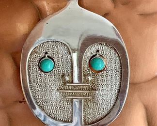 Item 138: Oswaldo Guayasamin - Equador - (1919-1999) was a sculptor, painter, jewelry designer, humanitarian and social activist. Pendant, 900 silver, turquoise eyes, signed. $400