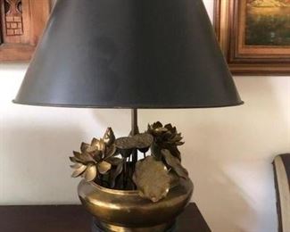 Brass lamp with lotus design and black shade, on credenza in dining room.