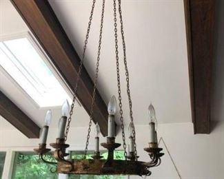Rustic chandelier, hanging over dining room table.