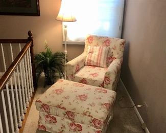Pink flowered chair and storage ottoman.