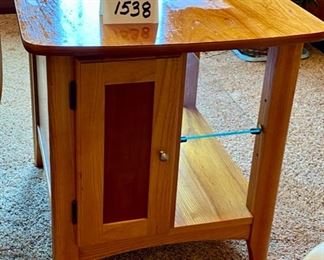 Lot 1538 $75.00 Maple Side Table w/ 1 Door in Front and Back, Glass Shelf, Maple and Cherry Veneers, The Top Surface shows wear and rough spots. Made by Riverside Furniture 26" D x 22" W x 24" H