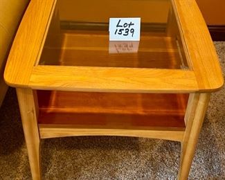 Lot 1539 $105.00 Matching Side Table with 18" Square Beveled Glass Top and Middle Shelf, Finished in Maple and Cherry Veneers, The Top Surface shows wear and rough spots by Riverside Furniture 26" Square x 24" H
