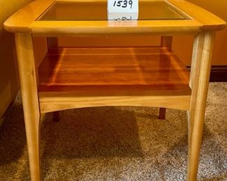 Lot 1539 $105.00 Matching Side Table with 18" Square Beveled Glass Top and Middle Shelf, Finished in Maple and Cherry Veneers, The Top Surface shows wear and rough spots by Riverside Furniture 26" Square x 24" H