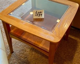 Lot 1539 $105.00 Matching Side Table with 18" Square Beveled Glass Top and Middle Shelf, Finished in Maple and Cherry Veneers, The Top Surface shows wear and rough spots by Riverside Furniture 26" Square x 24" H