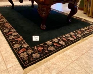 Lot 1561 $325.00. Nice Black Rug with Tan Leaf and Grape Leaf Design around the rim and Tan Fringe 134" L x 91" W (10'10" x 7'7")