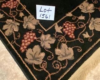 Lot 1561 $325.00. Nice Black Rug with Tan Leaf and Grape Leaf Design around the rim and Tan Fringe 134" L x 91" W (10'10" x 7'7")
