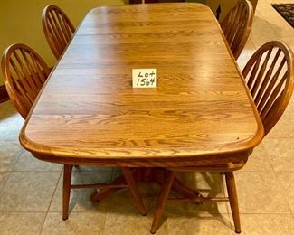 Lot 1564 $275.00 Solid Oak Kitchen Table w/ Under Table Leaf Storage and 4 Oak Spindle Back Chairs. Great for a Growing Family. Includes 1 Leaf. 49.5" L w/o Leaf x 34" W, Leaf is 17.75" W. Shown with Leaf
