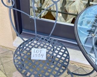 Lot 1584 $150.00 Wrought Iron Bistro Table with Glass Top and 2 Wrought Iron Chairs
