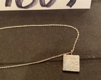 Lot 1607-A. Asking $150. Tiffany & Company necklace; 16" and Sterling Silver pendant has company name engraved in script