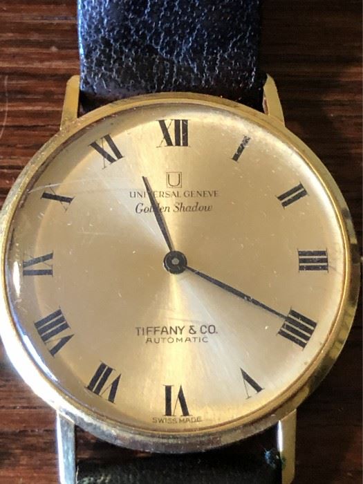 18K Gold Tiffany & Co Universal Geneve Golden Shadow Watch 25 Jewels. Marked 18k on inside of case. Original Tiffany & co leather wristband marked 18k on clasp. 
25 Jewels 2 Adjustments Automatic Swiss movement