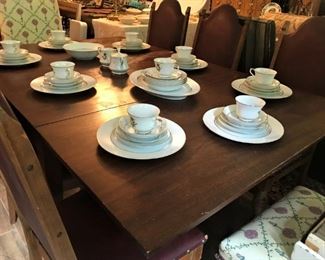 Antique mahogany drop leaf table, 6 leather-covered English pub chairs, two upholstered dining chairs, china place settings