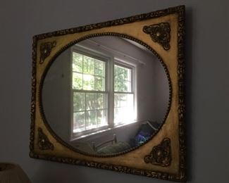 Oval mirror in square frame.