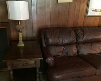 Brown leather sofa, end table and lamp.