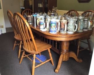 Very large Wooden Dining Table filled up with a huge collection of Beer Steins