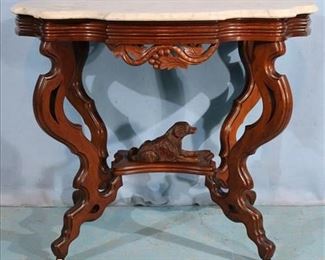 142a Walnut Victorian marble top table with carved dog in base and white turtle top, 29 in. T, 35 in W, 24 in. D.