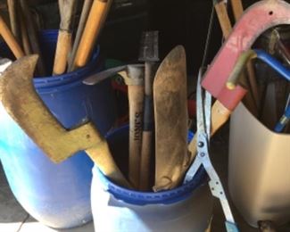 Assorted tools, including axes (some vintage), sledgehammers, rakes, shovels, hoes.