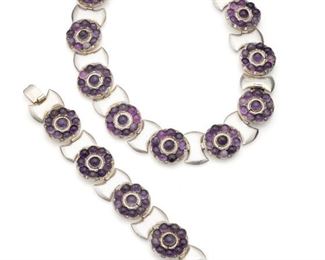 1017
A Set Of Fred Davis Silver And Amethyst Jewelry
Pre-1948; Mexico City, Mexico
Stamped: FD for Fred Davis; Further stamped: Silver / Mexico
Comprising a collar necklace (16.25" L x 1.125" H) and bracelet (7.5" L x .875" H) en suite designed with circular clusters of amethyst alternating with stylized shield-shaped panels, 2 pieces
158.0 grams
Estimate: $1,000 - $1,500