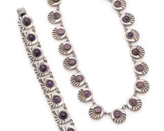 1018
An Assembled Set Of Fred Davis Silver And Amethyst Jewelry
Pre-1948; Mexico City, Mexico
Stamped: FD for Fred Davis; Further stamped: Mexico / Silver / Sterling
Comprising a round stylized scallop-link necklace (16" L x .5" H) set with amethyst cabochons together with a similar but non-matching bracelet (6.5" L x .625" H), 2 pieces
88.5 grams
Estimate: $800 - $1,200