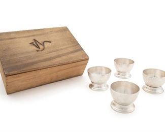 1033
An Assembled William Spratling Spirit Cup Set
Circa 1930s
Each marked to base for William Spratling: [WS Print] / Taxco; Nine further stamped: 920; Three further stamped: 900
The assembled set of twelve band-waisted cups with a flared foot in a wooden box with branded lid, 13 pieces
Each cup: 2" H x 2.625" Dia.; Box: 3.375" H x 9.625" W x 6.5" D
Estimate: $1,500 - $2,000