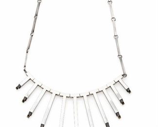 1076
A William Spratling Smoky Quartz And Silver Necklace
1951-1956; Third Design Period; Taxco, Mexico
WS Script mark with 925
The graduated bbib-style necklace tipped with smoky quartz suspended from T-form drops
18.25" L x 2.75" L
86.5 grams
Estimate: $1,000 - $1,500