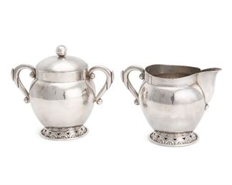 1093
A Hector Aguilar Sterling Silver Creamer And Sugar
1940-1945; Taxco, Mexico
Each stamped for Hector Aguilar; Further stamped: Taxco / 940
Comprising a cream jug and lidded sugar both with a round, half-disc designed foot
Cream jug: 3.75" H x 5.125" W x 3.5" D; Sugar: 4.5" H x 5.375" W x 3.25" D
14.770 oz. troy approximately
Estimate: $200 - $400