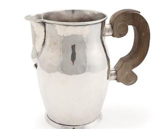 1134
A William Spratling Sterling Silver And Rosewood Pitcher
1940-1946; First Design Period; Taxco, Mexico
Stamped for William Spratling; Further stamped: Spratling Silver
The pitcher with rolled rim and scrolled wood handle on a small foot
7" H x 7.75" W x 4.75" D
21.600 gross oz. troy approximately
Estimate: $600 - $800