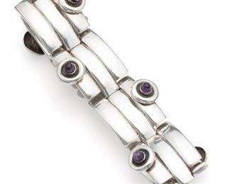1145
A William Spratling Sterling Silver And Amethyst Bangle Bracelet
1964-1967; Third Design Period; Taxco, Mexico
Stamped for William Spratling; Further stamped: 925 / Taxco Mexico / indistict eagle
The bamboo-link hinged bangle bracelet with cylindrical tapered amethyst
6.5" C x 1.25" H
71.5 grams
Estimate: $600 - $800